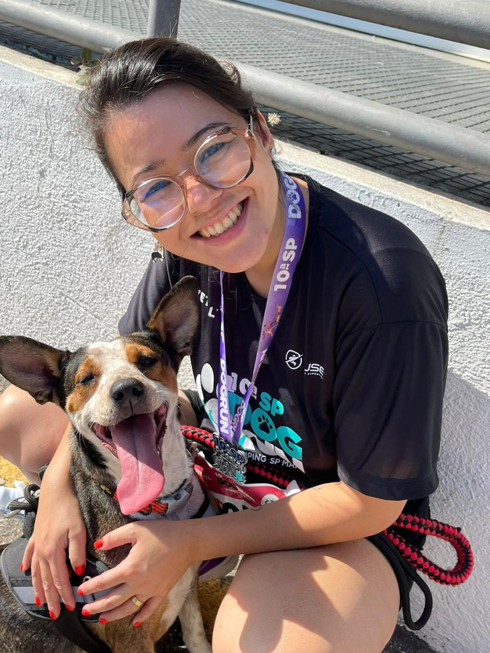 Tutora com cão e medalha de corrida